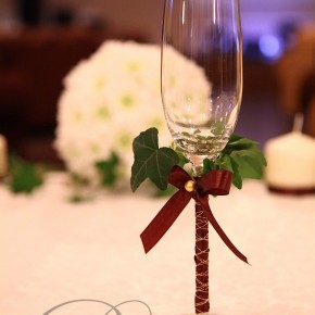 Свадебные бокалы, украшенные атласной лентой и плющём